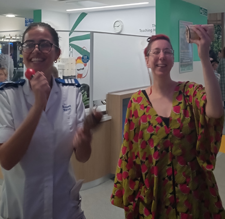 Two women laughing holding shakers in a hospital reception